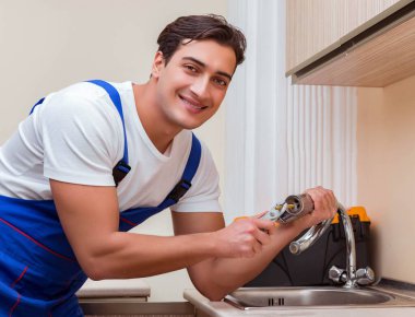 Mutfakta çalışan genç tamirci.