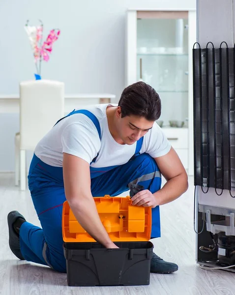 Reparador contratante reparação de geladeira no conceito DIY — Fotografia de Stock