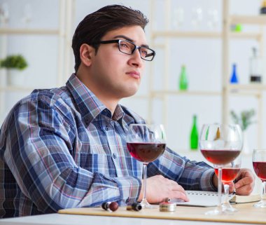 Profesyonel şarap garsonu kırmızı şarap tadıyor.