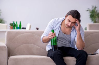 Genç alkolik erkek evde şarap içiyor.