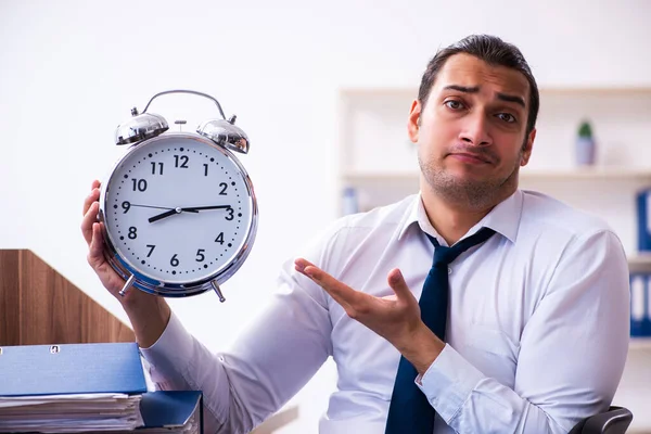 Jonge mannelijke werknemer ongelukkig met overmatig werk in het kantoor — Stockfoto