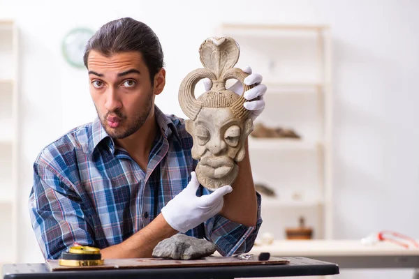 Молодой археолог изучает древнюю африканскую каменную маску — стоковое фото