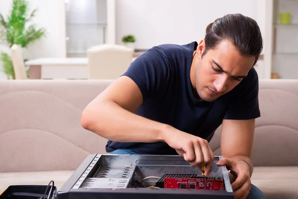 Jovem reparando computador em casa — Fotografia de Stock