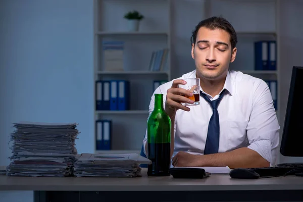 Podnikatel závislý na alkoholu pracuje dlouho do noci v kanceláři — Stock fotografie