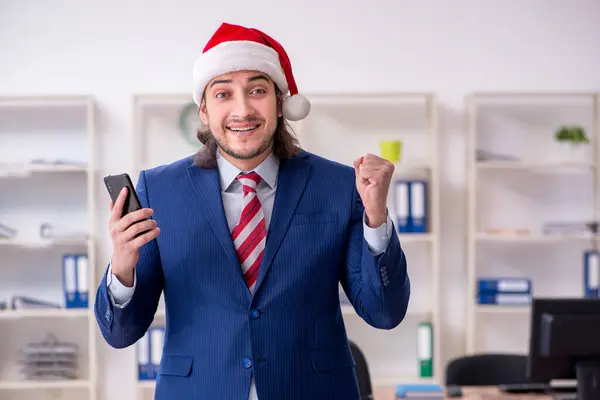 Молодий чоловік працює в офісі напередодні Різдва — стокове фото