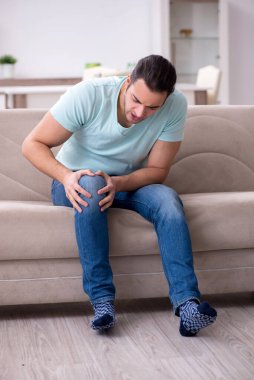 Evde acı çeken yaralı genç adam.