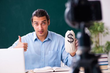 Genç yakışıklı öğretmen blogu için video kaydı yapıyor.