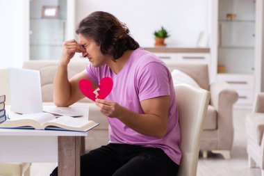 Evde tek taraflı aşk konsepti içinde genç bir erkek öğrenci