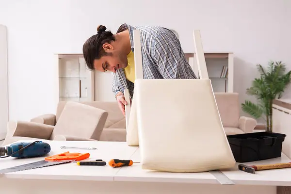 Young male carpenter repairing furniture at home — Stock Photo, Image