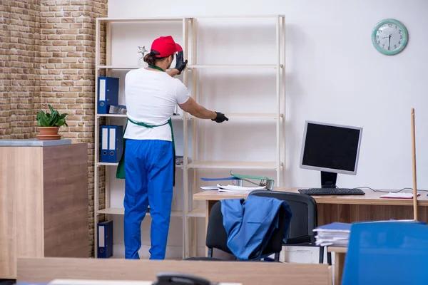 Joven contratista masculino limpiando la oficina — Foto de Stock