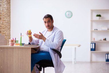 Klinikte çalışan genç erkek dişçi.