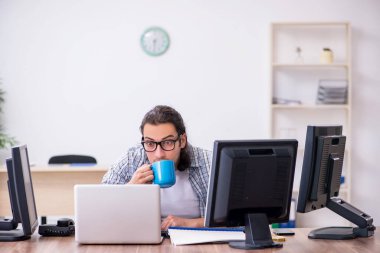 Ofiste çalışan genç bir erkek.