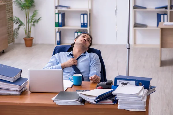 Giovane dipendente maschile che soffre sul posto di lavoro — Foto Stock