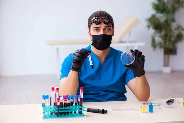 Młody biochemik badający próbki krwi w koncepcji pandemii — Zdjęcie stockowe