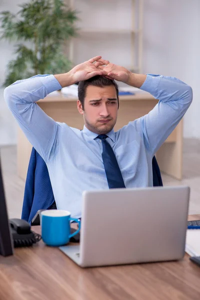 Giovane dipendente maschio infelice con il lavoro eccessivo — Foto Stock