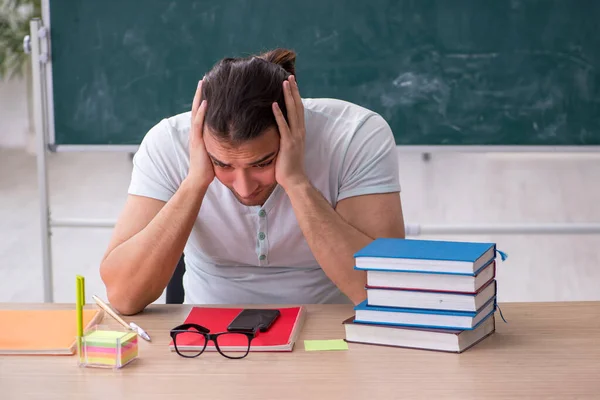 Jeune enseignant étudiant assis dans la classe — Photo