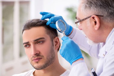 Genç adam deneyimli doktor dermatoloğu ziyaret ediyor.