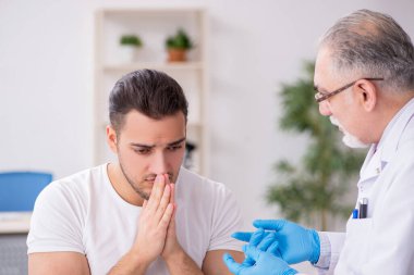 Genç adam deneyimli doktor dermatoloğu ziyaret ediyor.