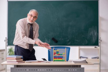 Sınıftaki yaşlı erkek öğretmen.