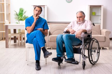 Tekerlekli sandalyedeki yaşlı adam ve genç kötü bakıcı.