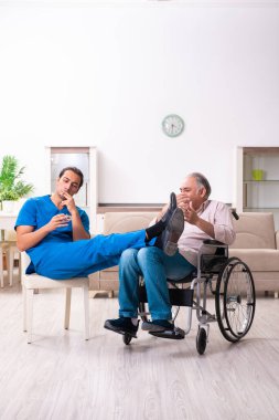 Tekerlekli sandalyedeki yaşlı adam ve genç kötü bakıcı.