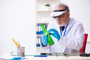 Kanıt için laboratuvarda çalışan yaşlı bir erkek kriminolog.