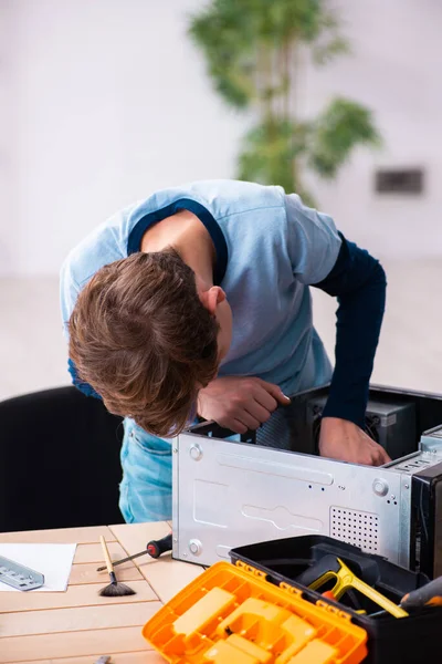 Мальчик чинит компьютеры в мастерской — стоковое фото