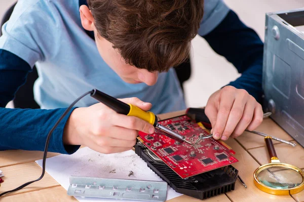 Jongen repareert computers op de werkplaats — Stockfoto