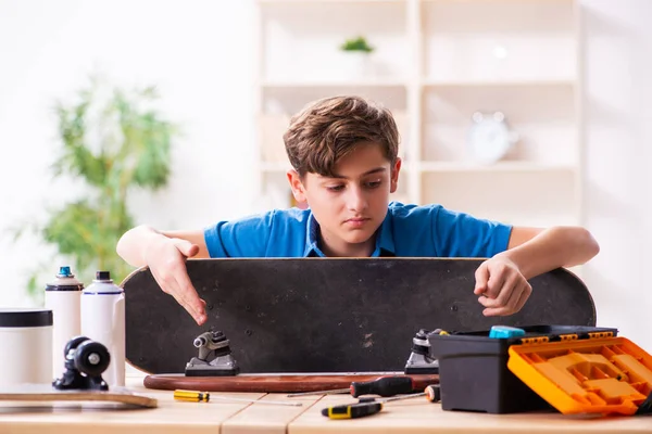 Junge repariert Skateboard zu Hause — Stockfoto