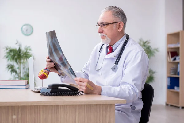 Klinikte çalışan yaşlı bir erkek radyolog. — Stok fotoğraf