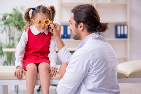 Menina pequena visitando jovem médico oculista masculino — Fotografia de Stock