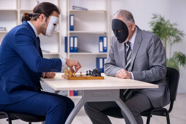 Två affärsmän som spelar schack i masker — Stockfoto