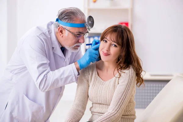 Young woman visiting old male doctor otorhinolaryngologist — Stock Photo, Image