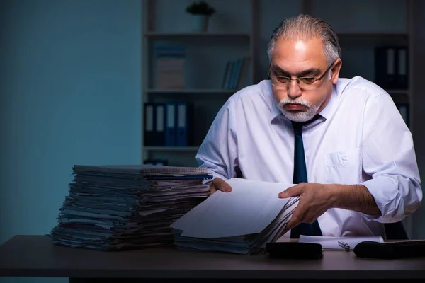 Velho empregado do sexo masculino trabalhando até tarde no escritório — Fotografia de Stock