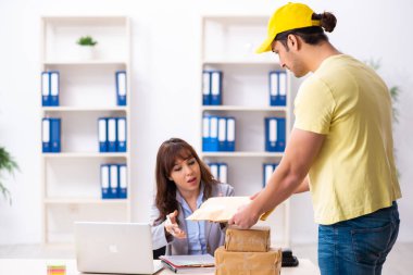 Genç erkek kurye ofise paket getiriyor.