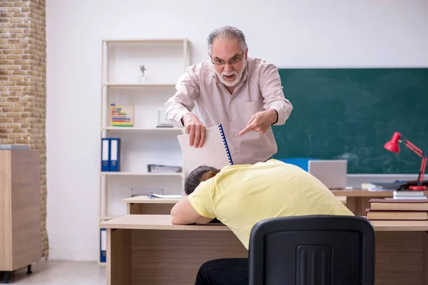 Viejo profesor y joven estudiante masculino en el aula — Foto de Stock