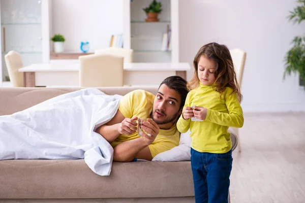 Menina pequena cuidando de seu pai doente — Fotografia de Stock