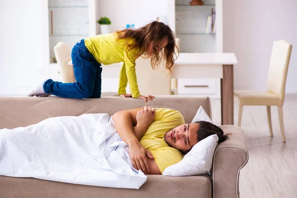 Menina pequena cuidando de seu pai doente — Fotografia de Stock