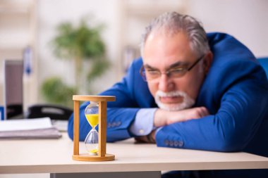 Zaman yönetimi konseptinde eski erkek çalışan işadamı