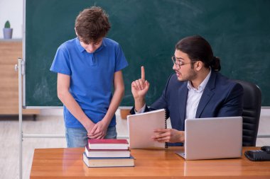 Genç erkek öğretmen ve okul çocuğu sınıfta.