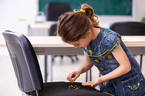 Middelbare school grap met scherpe duimspijkers op stoel — Stockfoto