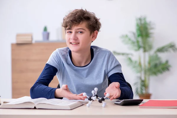 Schoolboy looking at molecular model at home — Stock Photo, Image