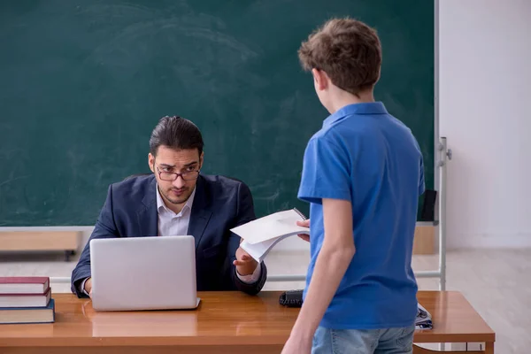 Jonge mannelijke leraar en schooljongen in de klas — Stockfoto