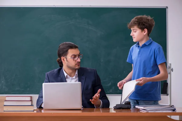 Fiatal férfi tanár és iskolás fiú az osztályteremben — Stock Fotó