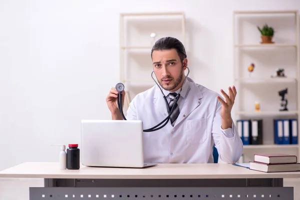 Jonge mannelijke arts werkzaam in de kliniek — Stockfoto