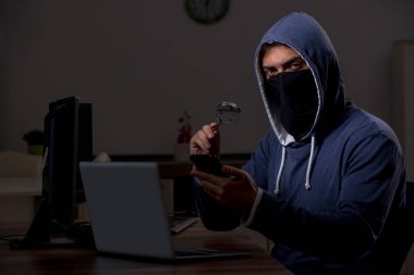 Erkek bilgisayar korsanı, güvenlik duvarını geç saatlerde hackliyor.