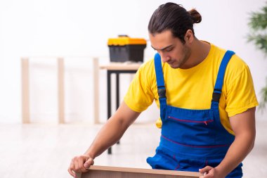 Genç erkek marangoz içeride çalışıyor.