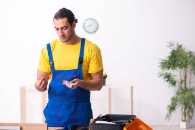 Genç erkek marangoz içeride çalışıyor.