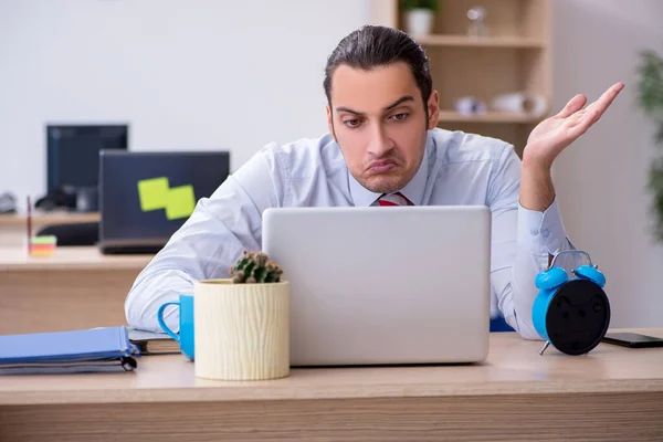 Joven empleado masculino en concepto de gestión del tiempo — Foto de Stock