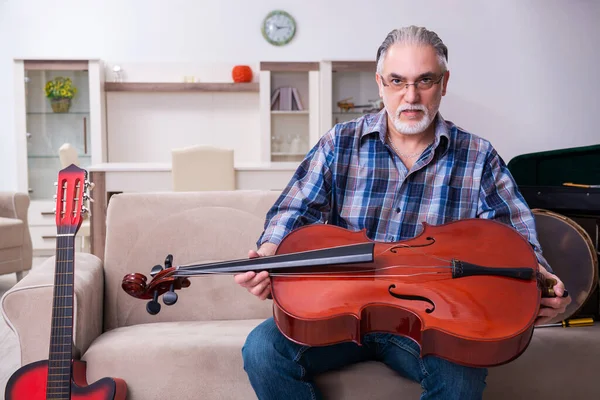Idősebb férfi szerelő hangszereket javít otthon — Stock Fotó